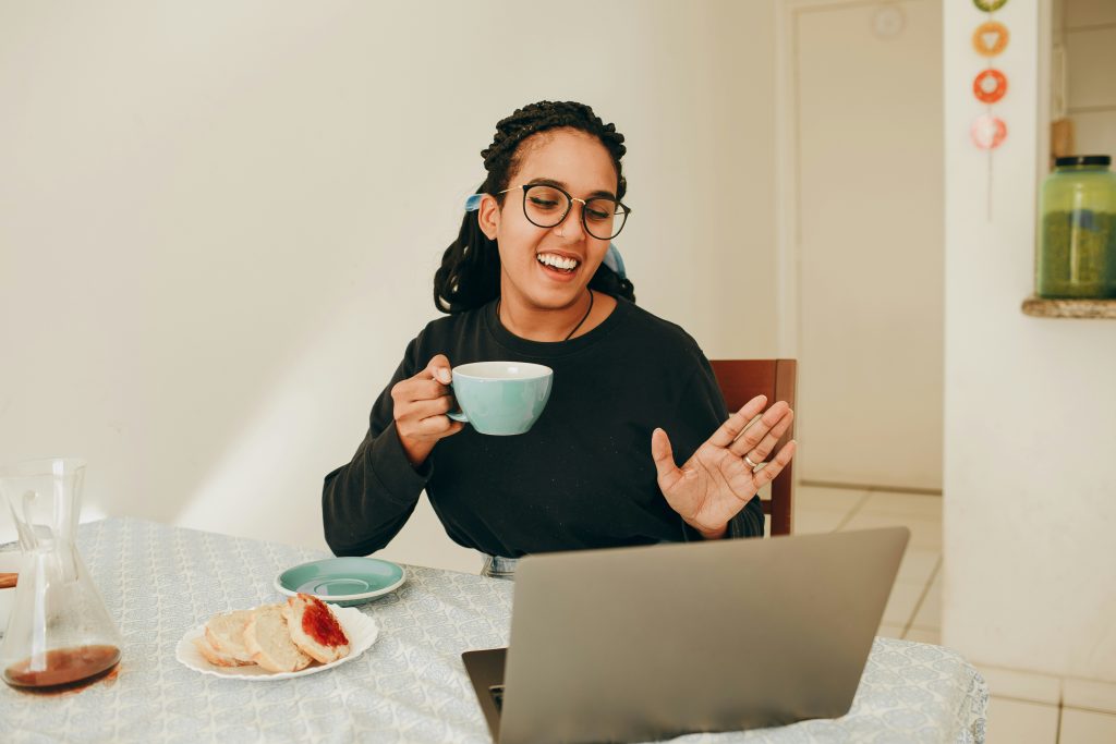 a young woman smiles and looks at a computer screen